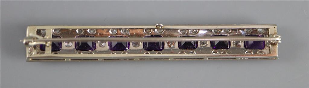 An early to mid 20th century 18ct white gold, amethyst and diamond cluster set bar brooch,